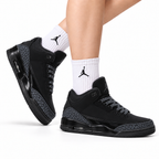 Air Jordan 3 Retro Triple Black sneakers on feet with Jordan socks