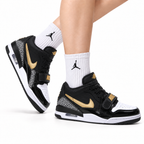 Jordan Legacy 312 Low Black White Metallic Gold sneakers on feet with Jordan socks